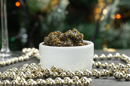 Black caviar. Black sturgeon caviar in a ceramic bowl and silver beads on a silver tray.の写真素材