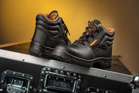 A pair of boots represented one near another, yellow backgroundの写真素材