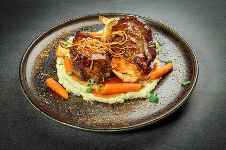 Braised meat with mashed potatoes and baby carrots ready for eating.の写真素材