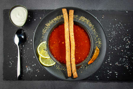 Tomato gazpacho, traditional Spanish cold soup or appetizer in a dark clay bowl on a stone boardの写真素材