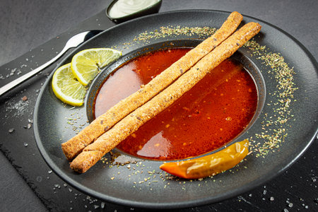 Tomato gazpacho, traditional Spanish cold soup or appetizer in a dark clay bowl on a stone boardの写真素材