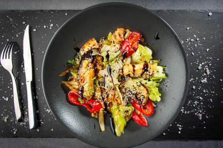 Grilled vegetables with sesame seeds on dark plateの写真素材