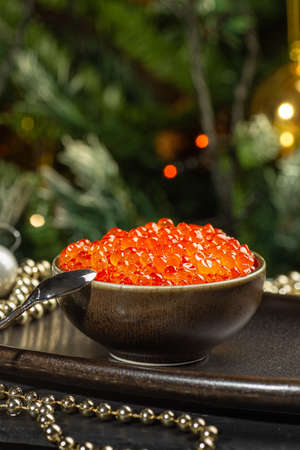 Red caviar in aa ceramic bowl, silver beads and pearls on a silver tray. Christmas and New Year backgroundの写真素材