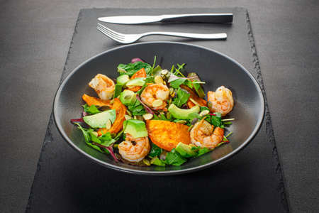 Salad with avocado and shrimps in bowl, front view, restaurant menuの写真素材