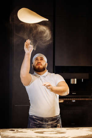 Making dough by hands at bakery or at home. Flour cloud in the air.の写真素材