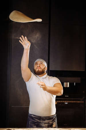 Making dough by hands at bakery or at home. Flour cloud in the air.の写真素材