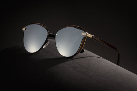 Trendy sunglasses background. Fashion summer accessories. Copy space for text. Black gold concept. Optic store discount posterの写真素材