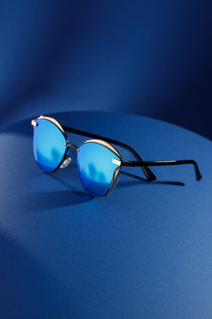 Trendy sunglasses background. Fashion summer accessories. Copy space for text. Blue concept. Optic store discount posterの写真素材
