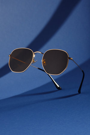 Trendy sunglasses background. Fashion summer accessories. Copy space for text. Blue gold concept. Optic store discount posterの写真素材