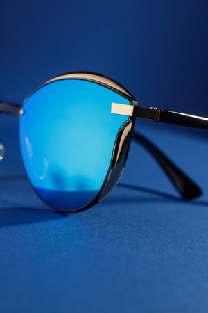 Trendy sunglasses background. Fashion summer accessories. Copy space for text. Blue concept. Optic store discount posterの写真素材