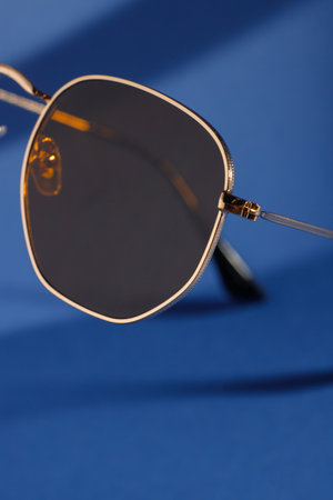 Trendy sunglasses background. Fashion summer accessories. Copy space for text. Black gold concept. Optic store discount posterの写真素材