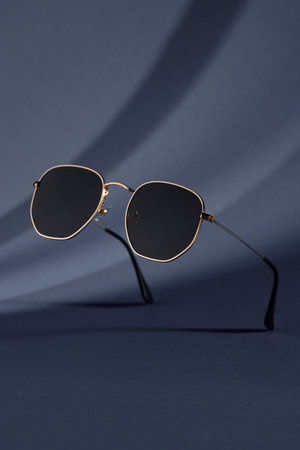 Trendy sunglasses background. Fashion summer accessories. Copy space for text. Black gold concept. Optic store discount posterの写真素材