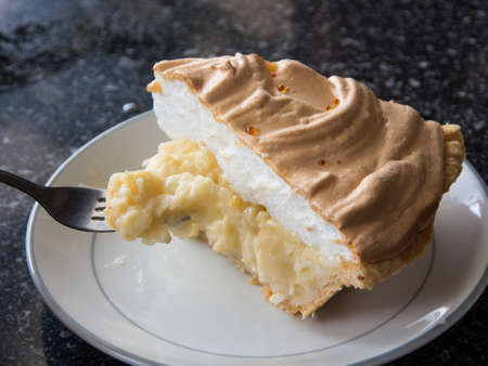 A piece of cake on a white dish with fork の写真素材