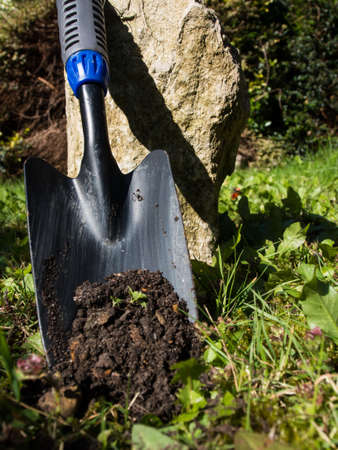Shovel with soil and white rock 