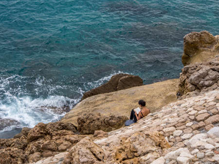 Women is reading a book by the sea in Monaco, France 