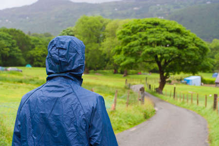 Man is looking at llansberis lake fron a hill in an overcast day in UK 