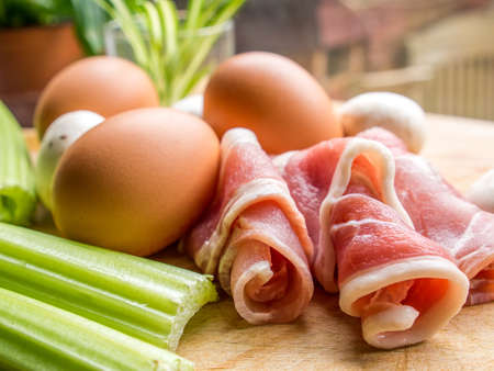 Red meat bacon rolled on a wooden board with mushroom の写真素材