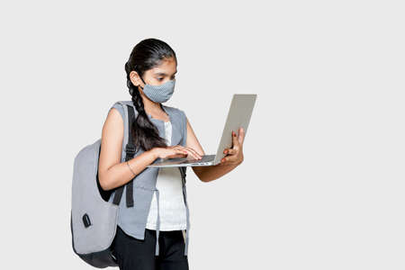 A young Indian girl is attending online school or classes.
