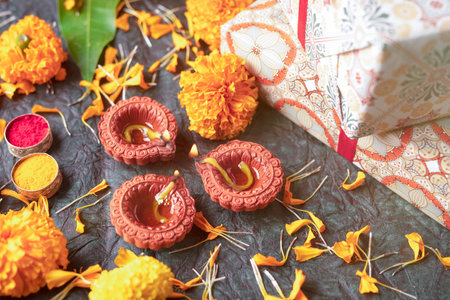 Beautiful clay Diya lamps lit during diwali celebration, Diwali gift and festival backgroundの写真素材