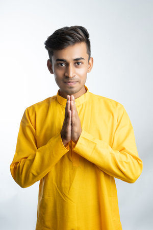 Young indian man in traditional wear and showing something in an empty space with the hands or fingersの写真素材