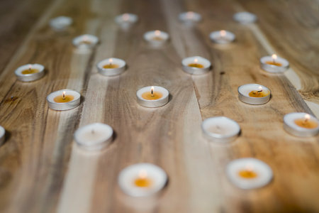selective focus on candles on reflecting surface and dark or bright backgroundの写真素材