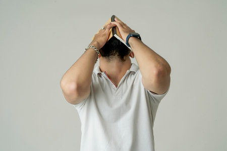 Young indian man standing with note book, isolated on whiteの写真素材