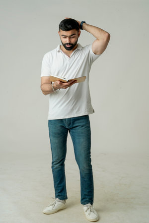 Young indian man standing with note book, isolated on whiteの写真素材
