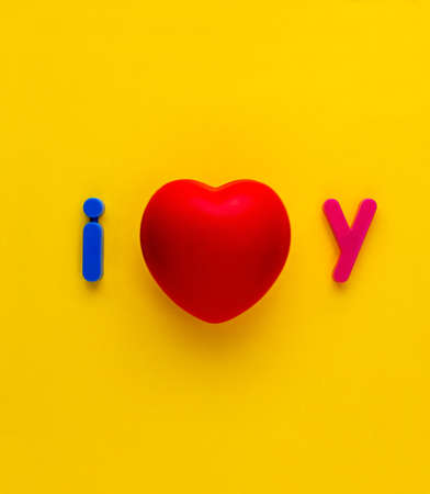 Red heart synbol with colourful  lettering I and y either side making I love you  on yellow...