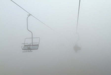 One of chair lifts in a ski resort in the fogの写真素材
