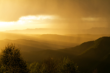 Gold suns rays at sunset in the thunderclouds of the mountainsの写真素材