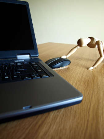 laptop,doll and mouse on the tableの写真素材