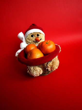 snowman with mandarines on red background        の写真素材