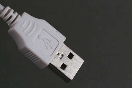 Close-up  of a  USB connection cable, isolated on dark backgroundの写真素材