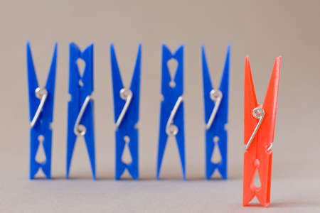 leadership concept. row of blue clothes pegs, with  red in a frontの写真素材