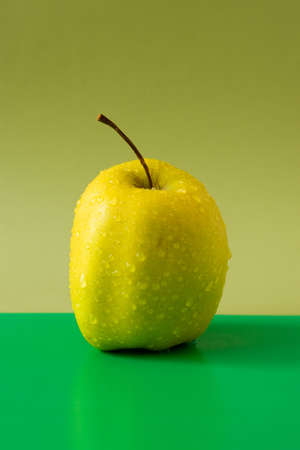 wet fresh apple isolated on green backgroundの写真素材
