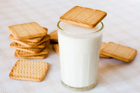 glass of fresh milk and cookies on the tableの写真素材