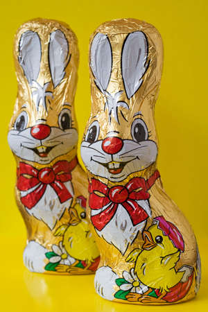Colorful chocolate easter bunnies, isolated over yellow