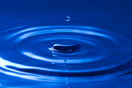 close-up of a droplet, falling in the blue water
