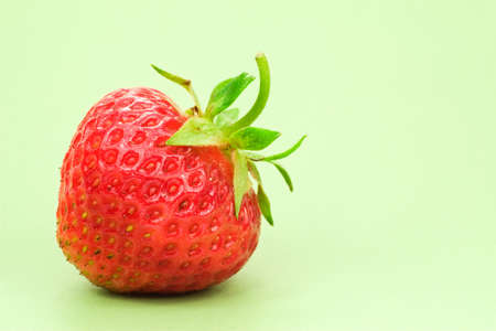 red fresh strawberry, isolated on green backgroundの写真素材