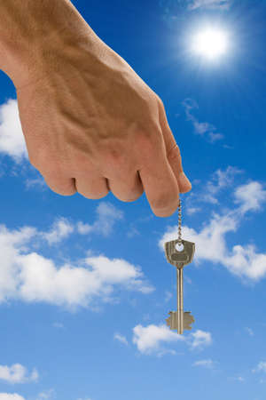 hand holding key,blue skies in the background の写真素材