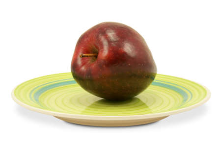 green plate with red apple on white backgroundの写真素材