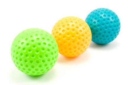 three colored golf balls over a white backgroundの写真素材