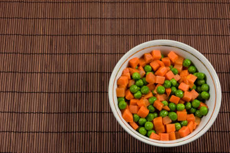 bowl with green peas and  carrots piecesの写真素材