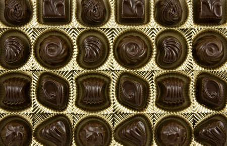 dark chocolate pralines in a golden boxの写真素材