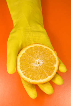 citrus fruit on human hand . isolated on orange backgroundの写真素材