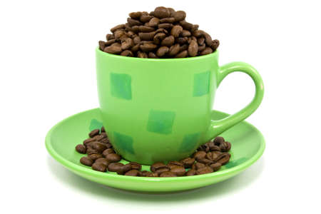 green cup with coffee beans over a white backgroundの写真素材