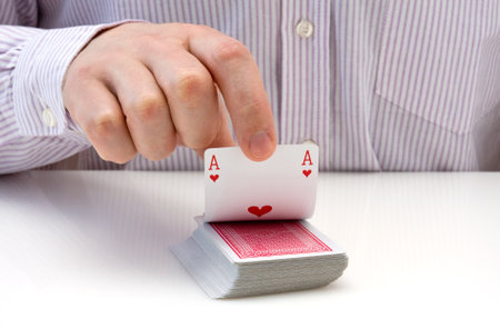 Man's hand lifting up playing card - ace of heartsのeditorial素材