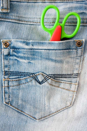 concept for  fashion and style. scissors in a jeans pocket. 