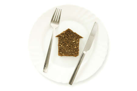 The silhouette of the house from bread lays on a plate