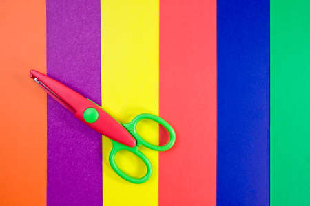 creativity concept. Colorful paper with child's scissors 